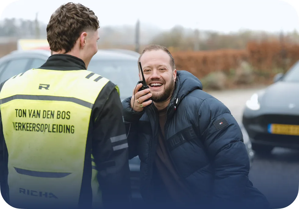 Twee instructeurs van Rijschool Ton van den Bos overleggen op het oefenterrein